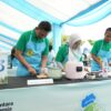General Manager PLN UID Sulselrabar, Edyansyah (kiri), Senior Manager Niaga dan Manajemen Pelanggan, Yuli Ashaniais (tengah), dan Senior Manager Keuangan, Komunikasi, dan Umum PLN UID Sulselrabar, Ambo Tuwo (kanan) memasak menggunakan peralatan listrik dalam ajang Electric Cook Fest di Monumen Mandala, Kota Makassar pada Sabtu (18/10).